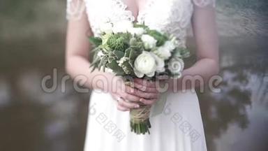 新娘穿着白色连衣裙，手里捧着不同颜色的美丽花束.. 新娘穿白色连衣裙，带束